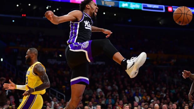 Mar 6, 2024; Los Angeles, California, USA; Sacramento Kings guard Malik Monk (0) reacts after dunking for the basket against Los Angeles Lakers forward LeBron James (23) during the first half at Crypto.com Arena. Mandatory Credit: Gary A. Vasquez-USA TODAY Sports