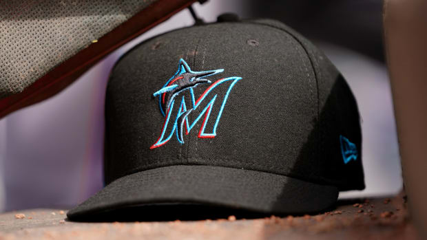 A Marlins hat is shown in the dugout.