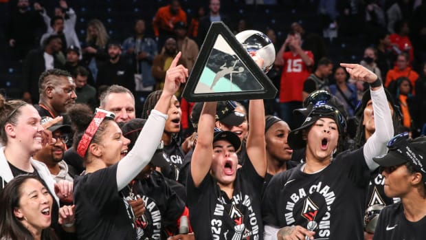 The 2023 Las Vegas Aces team hoists up the championship trophy.