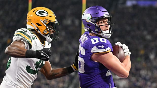 Dec 31, 2023; Minneapolis, Minnesota, USA; Minnesota Vikings tight end Johnny Mundt (86) scores a touchdown during the fourth quarter as Green Bay Packers cornerback Corey Ballentine (35) attempts to make the tackle at U.S. Bank Stadium.