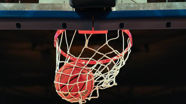 A basketball goes through a basketball hoop.