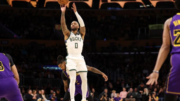 Milwaukee Bucks guard Damian Lillard (0) shoots the ball against Los Angeles Lakers guard D'Angelo Russell (1) during the first quarter at Crypto.com Arena. 