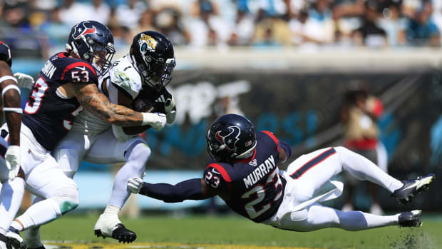 Jacksonville Jaguars running back Travis Etienne Jr. (1) rushes for yards against Houston Texans linebacker Blake Cashman (53) and safety Eric Murray (23) during the second quarter of an NFL football matchup Sunday, Sept. 24, 2023 at EverBank Stadium in Jacksonville, Fla. The Houston Texans defeated the Jacksonville Jaguars 37-17.