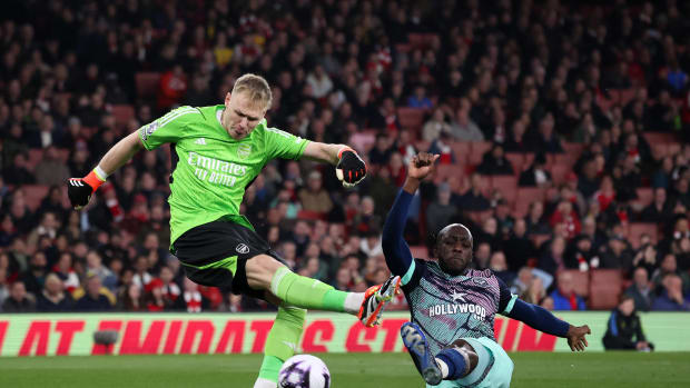 Yoane Wissa pictured (right) scoring for Brentford by tackling Arsenal goalkeeper Aaron Ramsdale during a Premier League game in March 2024