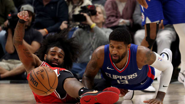 Chicago Bulls guard Coby White (0) and LA Clippers forward Paul George (13) dive for a loose ball during the fourth quarter at Crypto.com Arena. 
