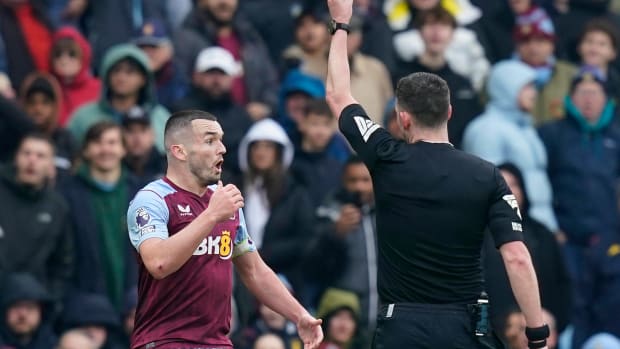 Aston Villa midfielder John McGinn pictured being shown a red card during his team's 4-0 defeat by Tottenham Hotspur in March 2024