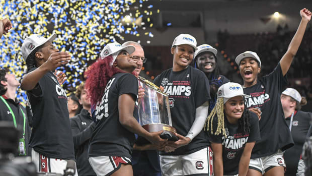 South Carolina women's basketball players celebrate with the trophy after winning the SEC tournament