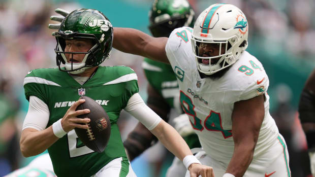 New York Jets quarterback Zach Wilson tries to elude the pressure of Miami Dolphins defensive tackle Christian Wilkins during the first half at Hard Rock Stadium in Miami Gardens, Dec. 17, 2023.