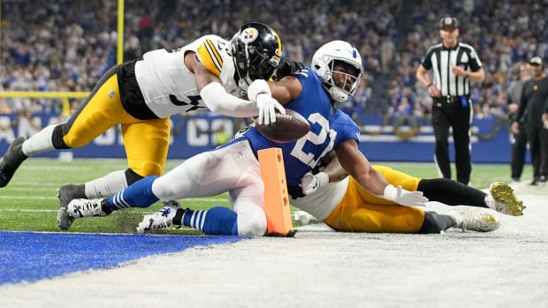 Indianapolis Colts running back Zack Moss (21) slides into the end zone for a touchdown while being chased by Pittsburgh Steelers linebacker Elandon Roberts (50) and Pittsburgh Steelers linebacker Mykal Walker (38) on Saturday, Dec. 16, 2023, during a game against the Pittsburgh Steelers at Lucas Oil Stadium in Indianapolis.