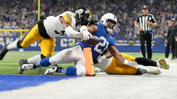 Indianapolis Colts running back Zack Moss (21) slides into the end zone for a touchdown while being chased by Pittsburgh Steelers linebacker Elandon Roberts (50) and Pittsburgh Steelers linebacker Mykal Walker (38) on Saturday, Dec. 16, 2023, during a game against the Pittsburgh Steelers at Lucas Oil Stadium in Indianapolis.  