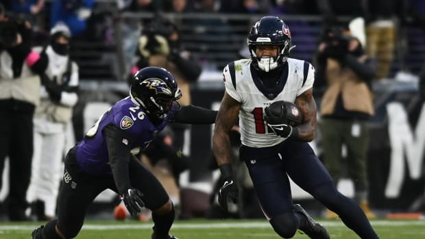 Jan 20, 2024; Baltimore, MD, USA; Houston Texans wide receiver Nico Collins (12) runs the ball against Baltimore Ravens safety Geno Stone (26) during the first quarter of a 2024 AFC divisional round game at M&T Bank Stadium. Mandatory Credit: Tommy Gilligan-USA TODAY Sports