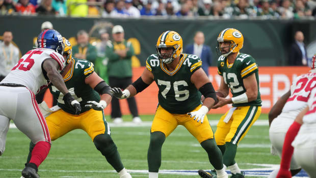 Oct 9, 2022; London, United Kingdom; Green Bay Packers guard Jon Runyan (76) blocks as quarterback Aaron Rodgers (12) drops back to pass against the New York Giants during an NFL International Series game at Tottenham Hotspur Stadium.