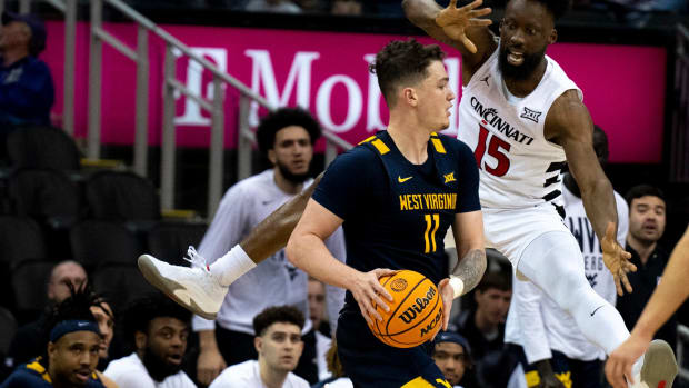 Cincinnati Bearcats forward John Newman III (15) guards West Virginia Mountaineers forward Quinn Slazinski (11) in the second half of the Big 12 Conference tournament between Cincinnati Bearcats and West Virginia Mountaineers at T-Mobile Center in Kansas City, Mo., on Tuesday, March 12, 2024.