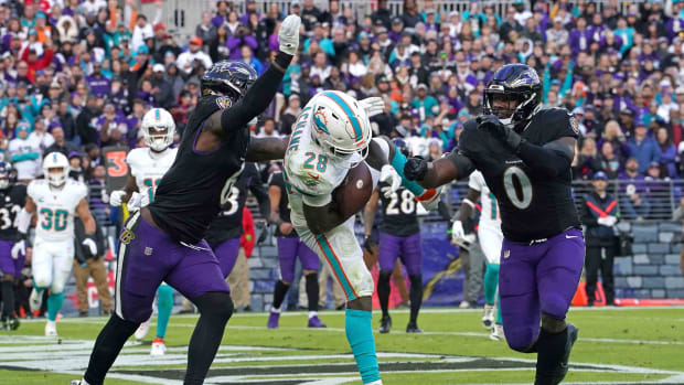 Dec 31, 2023; Baltimore, Maryland, USA; Miami Dolphins running back De Von Achane (28) makes a touchdown catch defended by Baltimore Ravens linebackers Patrick Queen (6) and Roquan Smith (0) in the fourth quarter at M&T Bank Stadium. Mandatory Credit: Mitch Stringer-USA TODAY Sports  