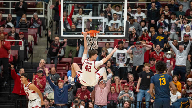 Mar 7, 2024; Stanford, California, USA; Stanford Cardinal forward Maxime Raynaud (42) celebrates hanging off the net after the dunked ball against the California Golden Bears during the second half at Maples Pavillion. Mandatory Credit: Neville E. Guard-USA TODAY Sports