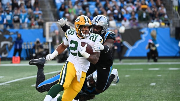 Dec 24, 2023; Charlotte, North Carolina, USA; Green Bay Packers running back AJ Dillon (28) with the ball as Carolina Panthers defensive tackle DeShawn Williams (96) and linebacker Brian Burns (0) defend in the fourth quarter at Bank of America Stadium.