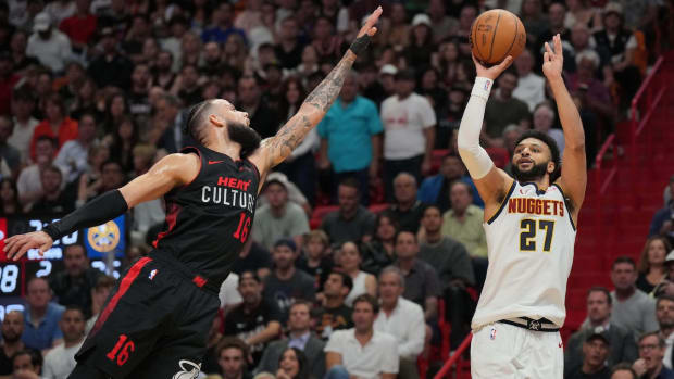 Denver Nuggets guard Jamal Murray (27) takes a shot over Miami Heat forward Caleb Martin (16) during the first half at Kaseya Center in Miami, Florida, on March 13, 2024.