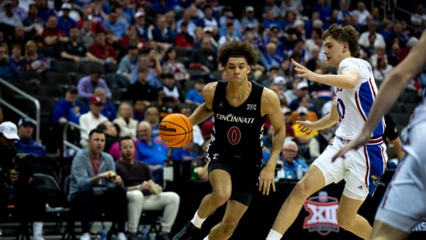 Cincinnati Bearcats guard Dan Skillings Jr. (0) drives on Kansas Jayhawks guard Johnny Furphy (10) in the second half of the Big 12 Conference tournament game between Cincinnati Bearcats and Kansas Jayhawks at T-Mobile Center in Kansas City, Mo., on Wednesday, March 13, 2024.