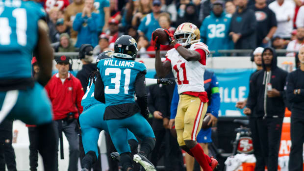 Nov 12, 2023; Jacksonville, Florida, USA; San Francisco 49ers wide receiver Brandon Aiyuk (11) catches the ball under pressure from corner back Tyson Campbell (32) and corner back Darious Williams (31) during the third quarter at EverBank Stadium. Mandatory Credit: Morgan Tencza-USA TODAY Sports  