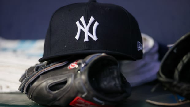 Aug 14, 2023; Atlanta, Georgia, USA; A detailed view of a New York Yankees hat and glove on the bench against the Atlanta Braves in the third inning at Truist Park.