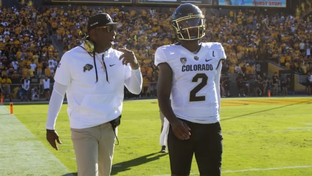 Colorado Buffaloes coach Deion Sanders with son and quarterback Shedeur Sanders (2) against the Arizona State Sun Devils at Mountain America Stadium.