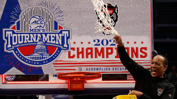Mar 16, 2024; Washington, D.C., USA; North Carolina State Wolfpack head coach Kevin Keatts reacts by cutting the net from the basketball rim after defeating the North Carolina Tar Heels at Capital One Arena.