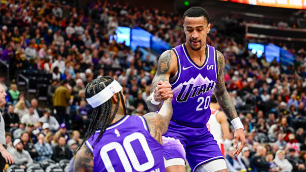 Mar 4, 2024; Salt Lake City, Utah, USA; Utah Jazz forward/center John Collins (20) helps guard Jordan Clarkson (00) off the ground against the Washington Wizards during the second half at the Delta Center. Mandatory Credit: Christopher Creveling-USA TODAY Sports