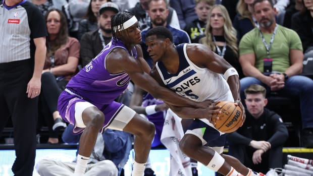 Utah Jazz forward Taylor Hendricks (0) reaches for the ball held by Minnesota Timberwolves guard Anthony Edwards (5) during the second quarter at Delta Center in Salt Lake City on March 18, 2024.