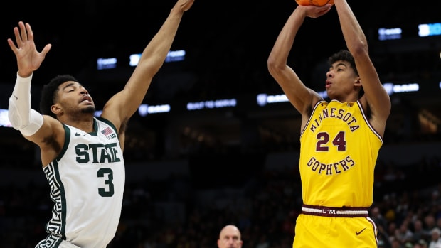 Mar 14, 2024; Minneapolis, MN, USA; Minnesota Golden Gophers guard Cam Christie (24) shoots as Michigan State Spartans guard Jaden Akins (3) defends during the second half at Target Center.