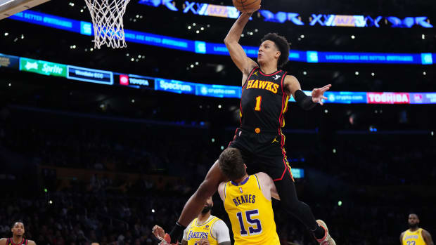 Mar 18, 2024; Los Angeles, California, USA; Atlanta Hawks forward Jalen Johnson (1) dunks the ball over Los Angeles Lakers guard Austin Reaves (15) in the first half at Crypto.com Arena. Mandatory Credit: Kirby Lee-USA TODAY Sports