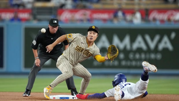 Sep 13, 2023; Los Angeles, California, USA; Los Angeles Dodgers right fielder Mookie Betts (50) slides into second base to beat a throw to San Diego Padres second baseman Ha-Seong Kim (7) for a stolen base in the first inning at Dodger Stadium.