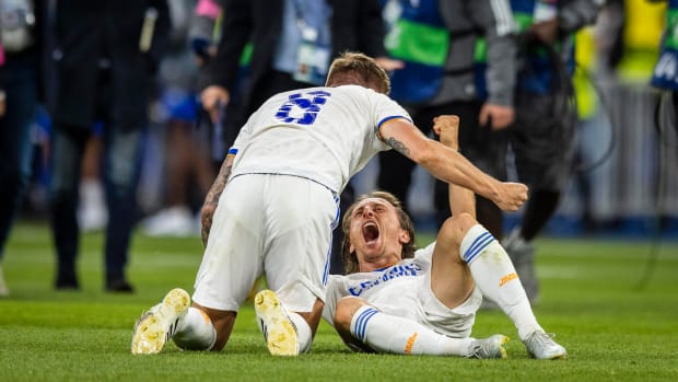 Real Madrid teammates Toni Kroos (left) and Luka Modric pictured celebrating on the field after winning the 2022 UEFA Champions League final against Liverpool at the Stade de France