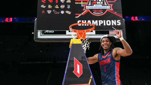 Mar 17, 2024; Brooklyn, NY, USA; Duquesne Dukes guard Jimmy Clark III (1) cuts the nets after winning the Atlantic 10 Tournament Championship at Barclays Center. Mandatory Credit: Wendell Cruz-USA TODAY Sports
