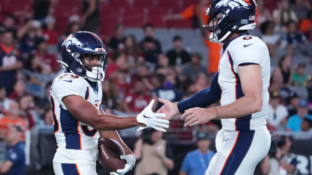 Denver Broncos running back Jaleel McLaughlin (38) slaps hands with Denver Broncos quarterback Ben DiNucci (6) after scoring a touchdown against the Arizona Cardinals during the second half at State Farm Stadium.