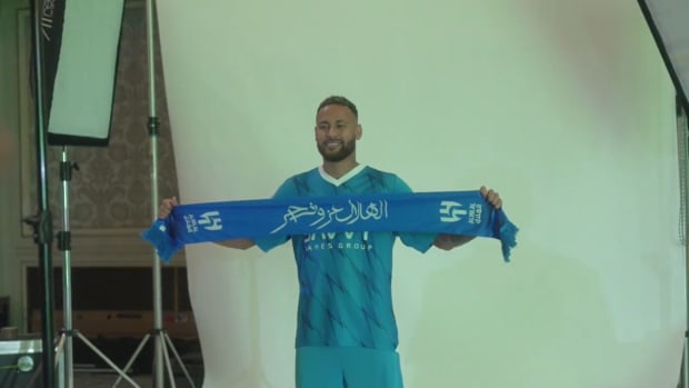 Neymar pictured wearing Al-Hilal kit and holding up a scarf after completing his transfer to the Saudi Pro League club from PSG in August 2023