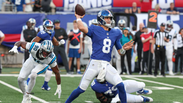 Aug 18, 2023; East Rutherford, New Jersey, USA; New York Giants quarterback Daniel Jones (8) throws the ball during the first quarter as Carolina Panthers linebacker Amare Barno (90) pursues at MetLife Stadium.