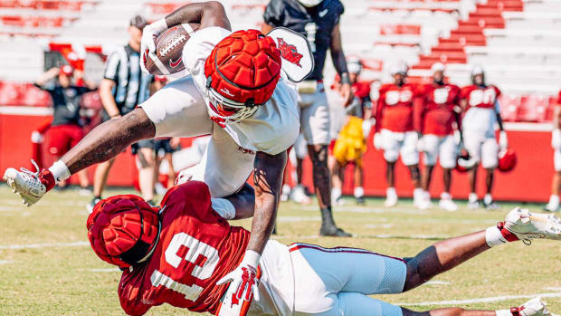 Razorback runner is tackled by defensive back Alfahiym Walcott at Saturday scrimmage