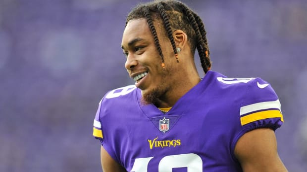 Vikings wide receiver Justin Jefferson smiles without a helmet before a game.