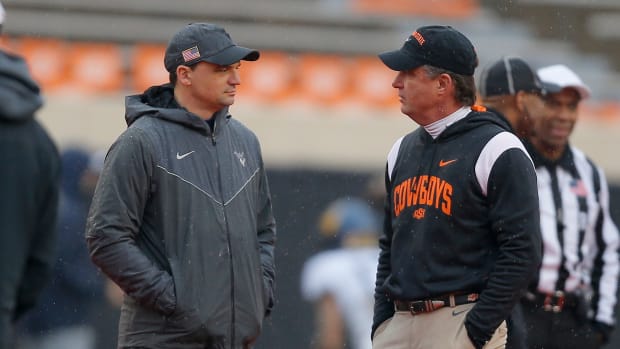 West Virginia Mountaineers head coach Neal Brown, left, and Oklahoma State Cowboys head coach Mike Gundy talk before a college football game between Oklahoma State and West Virginia at Boone Pickens Stadium in Stillwater, Okla., Saturday, Nov. 26, 2022. Osu Football Vs West Virginia