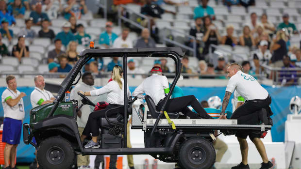 The Dolphins' Daewood Davis is carted off during a preseason game.