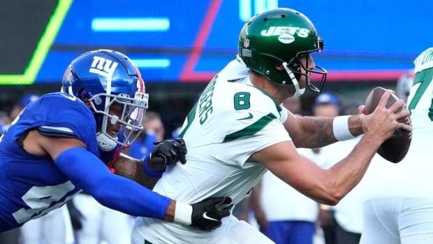 Aug 26, 2023; East Rutherford, New Jersey, USA; New York Jets quarterback Aaron Rodgers (8) pressured by New York Giants inside linebacker Isaiah Simmons (left) during the first half at MetLife Stadium.