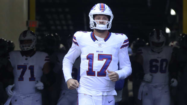 Josh Allen runs out of the tunnel with other Bills players behind him