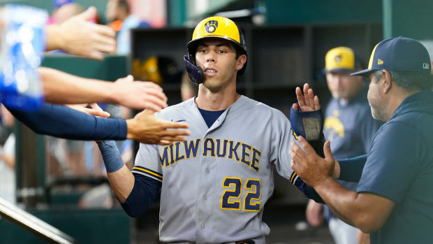Aug 20, 2023; Arlington, Texas, USA; Milwaukee Brewers left fielder Christian Yelich (22) celebrates with teammates in the dugout after scoring on a bases loaded walk against the Texas Rangers during the third inning at Globe Life Field.