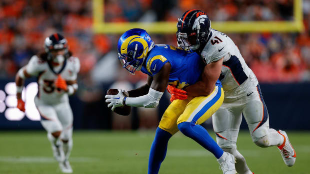 Los Angeles Rams wide receiver Tyler Johnson (14) is tackled by Denver Broncos linebacker Drew Sanders (41) in the first quarter at Empower Field at Mile High.