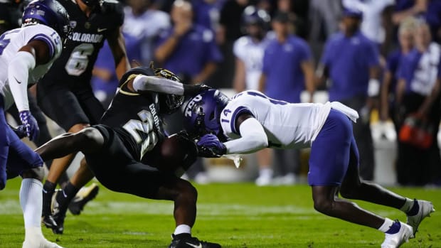 TCU Horned Frogs safety Abraham Camara (14) tackles Colorado Buffaloes running back Deion Smith (20) in the first quarter at Folsom Field.