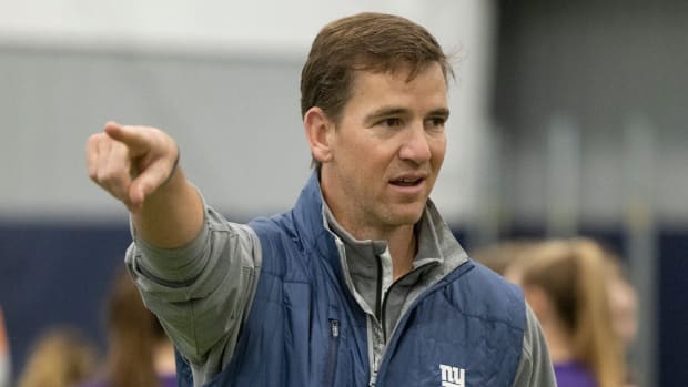 Former Giants quarterback Eli Manning helps with a team girls football clinic.