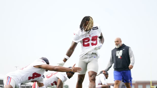 Jul 27, 2023; East Rutherford, NJ, USA; New York Giants safety Xavier McKinney (29) and offensive line coach Bobby Johnson, right, greet players on day two of training camp at the Quest Diagnostics Training Facility.