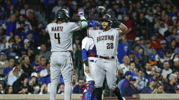 Arizona Diamondbacks left fielder Tommy Pham (28) celebrates with Ketel Marte (4) at home plate after hitting a two-run home run in the top of the 8th against the Chicago Cubs at Wrigley Field.