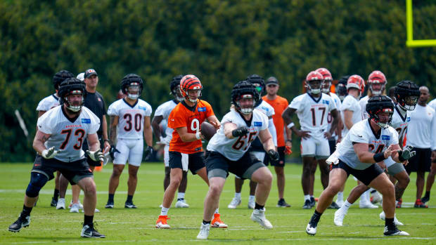 Cincinnati Bengals quarterback Joe Burrow (9) takes a snap behind the offensive line during a training camp practice at the Paycor Stadium practice field in downtown Cincinnati on Wednesday, July 26, 2023.  