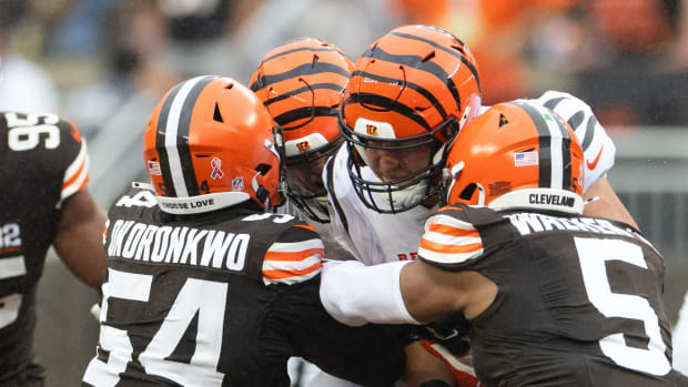 Sep 10, 2023; Cleveland, Ohio, USA; Cincinnati Bengals quarterback Joe Burrow (9) is tackled by Cleveland Browns defensive end Ogbo Okoronkwo (54) and defensive end Ogbo Okoronkwo (54) during the first quarter at Cleveland Browns Stadium. Mandatory Credit: Scott Galvin-USA TODAY Sports